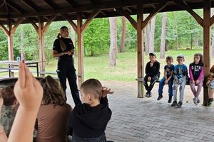 policjantka prowadzi prelekcje dla dzieci, które zgłaszają się do odpowiedzi oraz kolorują kolorowanki
