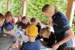 policjantka prowadzi prelekcje dla dzieci, które zgłaszają się do odpowiedzi oraz kolorują kolorowanki