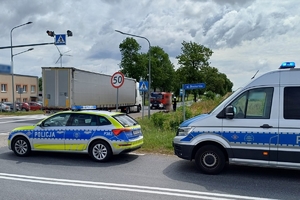 policjanci wykonują czynności na miejscu zdarzenia drogowego, na zdjęciu widać samochód ciężarowy oraz uszkodzony rower oraz oznakowane radiowozy