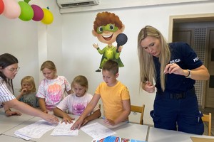 Zdjęcie przedstawia policjantki oraz dzieci przy stole.