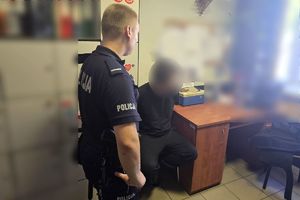 Zdjęcie przedstawia policjanta stojącego obok zatrzymanego.