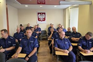 Zdjęcie przedstawia policjantów w sali.