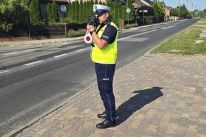 umundurowany policjant z drogówki mierzy prędkość