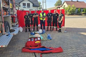 zdjęcie grupowo, strażacy i policjant biorący udział w działaniach profilaktycznych
