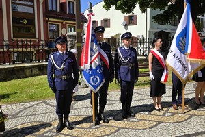 uczestnicy obchodów maszerują oraz składają wiązanki kwiatów pod miejscami pamięci narodowej