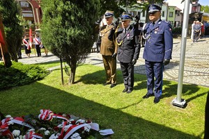 uczestnicy obchodów maszerują oraz składają wiązanki kwiatów pod miejscami pamięci narodowej