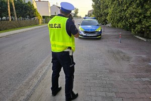 policjant stoi z miernikiem prędkości - mierzy prędkość