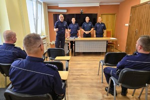 na zdjęciu widać 4 stojących policjantów i 3 siedzących na krzesłach policjantów