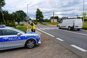 umundurowany policjant kontroluje ruch w rejonie przejścia dla pieszych