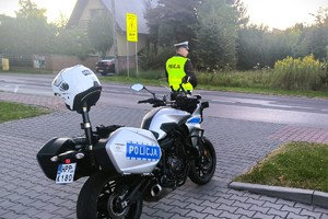 policjant stoi przy motocyklu policyjnym