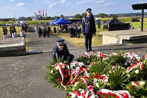 Umundurowany policjant składa kwiaty pod pomnikiem