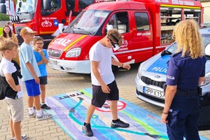 umundurowane policjantki wraz z grupą młodzieży i dzieci oraz sznupek