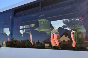 policjant kontroluje wnętrze autobusu