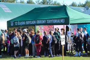 stoisko wojsk obrony terytorialnej w kolorze zielonym, obok stoją uczniowie