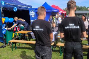 uczniowie z klasy mundurowej stoją przy stoisku policyjnym