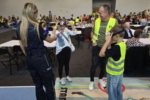na zdjęciu policjanci oraz uczestnicy festynu, dzieci w kamizelkach odblaskowych, policjanci w mundurach oraz strażacy ochotnicy