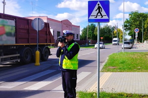 policjant kontroluje prędkość w rejonie przejścia dla pieszych