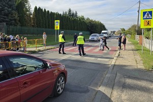 policjanci i policjantki pokazują dzieciom jak w praktyce poprawnie przechodzić przez przejście dla pieszych