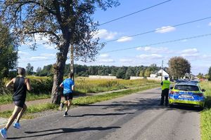 policja a w radiowozie zabezpiecza trasę biegu