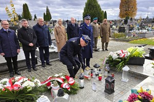 Delegacja służb mundurowych podczas zapalania zniczy przy zbiorowej mogile żołnierzy.