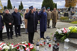 Uczestnicy uroczystości oddający hołd przy grobie poległych żołnierzy.