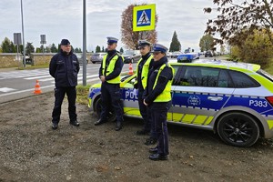 umundurowani policjanci stoją przy radiowozie w rejonie cmentarza