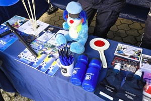Materiały informacyjne oraz elementy wyposażenia prezentowane na policyjnym stoisku podczas wydarzenia w Krzepicach.