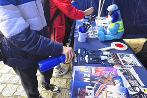 Materiały informacyjne oraz elementy wyposażenia prezentowane na policyjnym stoisku podczas wydarzenia w Krzepicach.