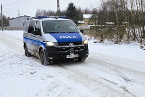 radiowóz jedzie po zaśnieżonej drodze