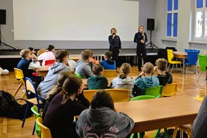 policjantki prowadzą prelekcje, stoją przed dziećmi, które siedzą na krzesełkach