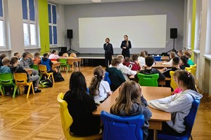 policjantki prowadzą prelekcje, stoją przed dziećmi, które siedzą na krzesełkach