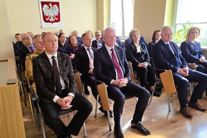 Odprawa służbowa policjantów, na zdjęciu widać grupę umundurowanych policjantów oraz kobiety i mężczyzn ubranych po cywilnemu, w tle rzutnik, na którym prezentowane są treści dotyczące bezpieczeństwa powiatu kłobuckiego