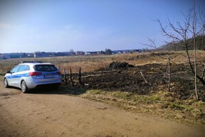 radiowóz stoi przy wypalonej łące