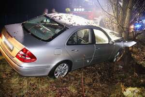 srebrny mercedes z uszkodzeniami po uderzeniu w drzewo