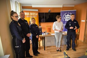 Podpisanie porozumienia o współpracy pomiędzy Komendą Powiatową Policji w Kłobucku a Zespołem Szkół Numer 3 w Kłobucku – uczestnicy spotkania stoją w sali