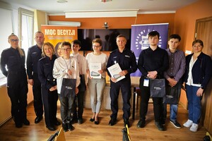 Przedstawiciele policji i szkoły po podpisaniu porozumienia – wspólne zdjęcie przy stole.