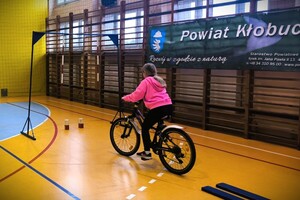 Uczeń wykonuje zadanie na torze przeszkód sprawdzającym umiejętności jazdy na rowerze.