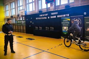 Policjant obserwuje przejazd uczestnika podczas konkurencji rowerowej.