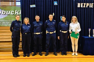 policjantki i dyrektor szkoły stoją na hali sportowej