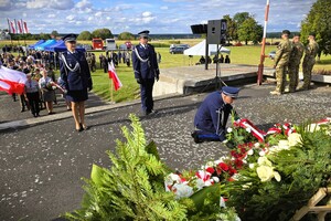 uroczystość przy pomniku Bohaterów Bitwy pod Mokrą, w tle uczestnicy uroczystości, żołnierze oraz służby mundurowe